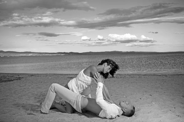 Pareja enamorada de cuerpo sexy relajarse en la arena de la playa. Familia y día de San Valentín. Vacaciones de verano y vacaciones de viaje paraíso. Mujer sexy y el hombre tienen juegos sexuales. Relaciones amorosas de pareja desnuda en el mar . — Foto de Stock