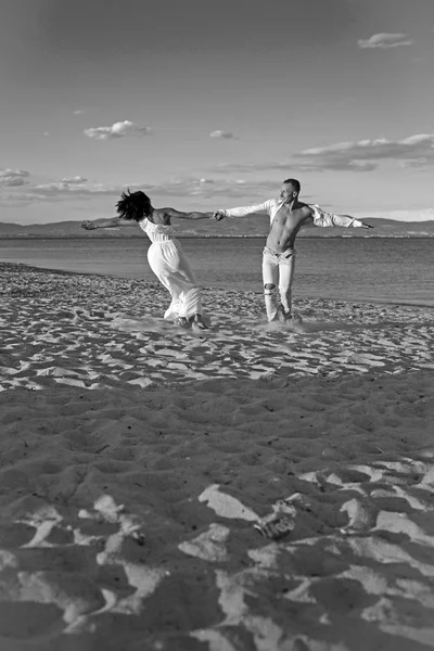 夏の休日や休暇を旅行します。一緒に夏の日を楽しんでいるカップルのダンスの関係が大好きです。セクシーな女と海の男。家族とバレンタインの日。ビーチの砂の上で踊る恋カップル — ストック写真