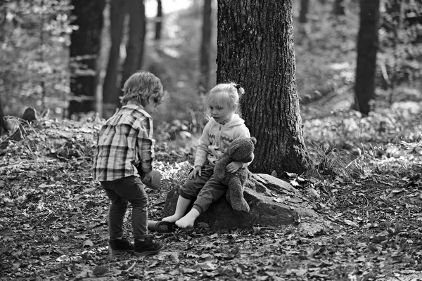 Brother help sister to put red boots. Little boy put shoes on girl feet. Helping hand concept. Children getting ready for walk in autumn forest. Childhood friendship, love and trust — Stock Photo, Image