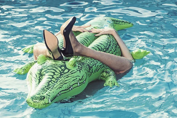 Mulher no mar com colchão inflável. sapatos de couro de crocodilo. pernas femininas segurar colchão na piscina. Sapatos de moda de pele de crocodilo. Aventuras de menina em crocodilo em férias de verão — Fotografia de Stock