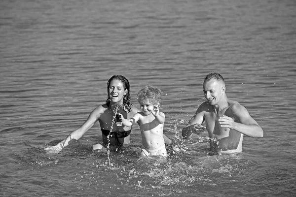 Dziecko z ojca i matki. dziecko gry w wodzie z rodzicami. — Zdjęcie stockowe