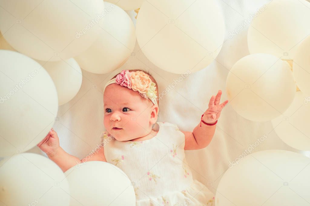 Like on catwalk. Sweet little baby. New life and birth. Small girl. Happy birthday. Family. Child care. Childrens day. Portrait of happy little child in white balloons. Childhood happiness