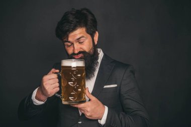 Mutlu ve zarif bir adam bira içiyor. Bira. Sakallı adam bira içiyor.