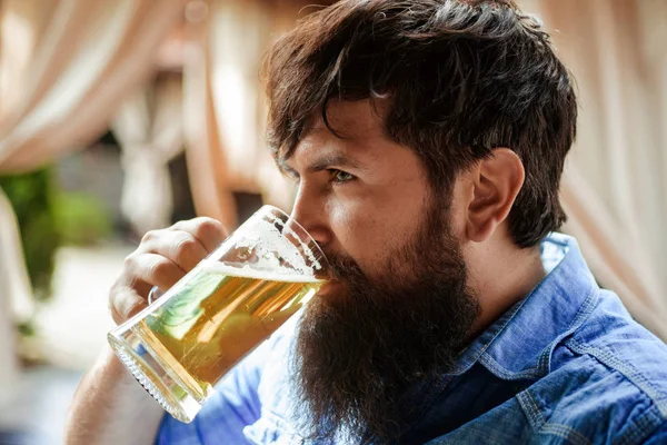 Happy elegant man drinking beer. Sexy bearded man open smile and big mug of beer in his hand. Bearded man drinking lager beer. — Stock Photo, Image