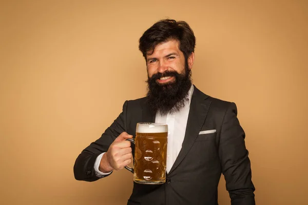Sexy bearded man open smile and big mug of beer in his hand. Happy smiling man with beer. Man holding mug of beer.