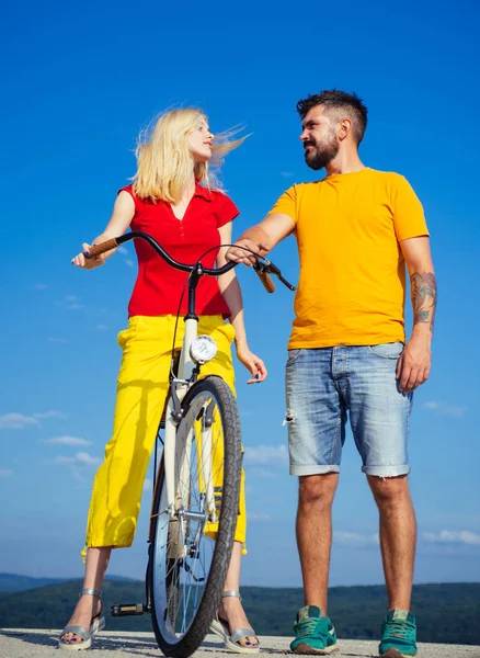 Retirement. Happy funny young couple riding on bicycle. Young riders enjoying themselves on trip. summer holidays - love romance and people concept.
