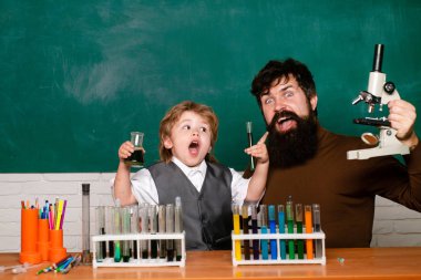 İlkokul öğretmeni ve sınıfta öğrenci. Ders Planları - Ortaokul Kimya. Okul dersindeki küçük çocuklar. Çocukluk eğitimi kavramı.