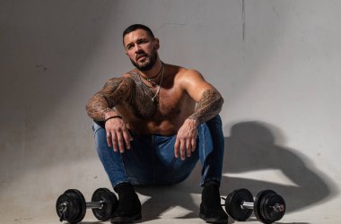 dumbell kaldırma. dövme adam seksi abs. erkek modası. atletik vücutile kaslı maço adam. halterli acımasız sporcu. Steroid. güven karizması. spor ve fitness. güçlü adam egzersiz