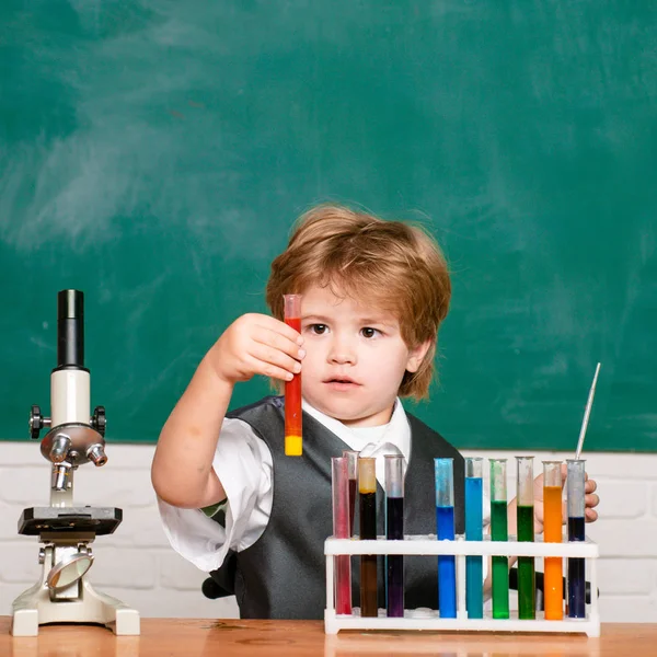 De genomförde ett nytt experiment i kemi. Kid lär sig i klass på bakgrund av Blackboard. Kunskaps dag. Skolpojke. 1 september. — Stockfoto