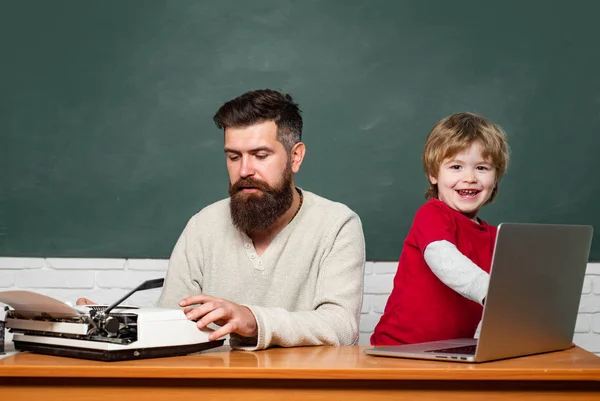 Young adult concept. Elementary school kid and teacher in classroom at school. School children. Chalkboard background. Man teacher play with preschooler child. — Stock Photo, Image