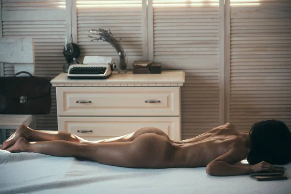 Νιώθω ευχαρίστηση. Σέξι γυναίκα με γυμνό σώμα χαλαρωτικό στον καναπέ μασάζ. Γυμνό σώμα γυναίκας στο Ινστιτούτο φροντίδας σώματος. Αισθησιακό κορίτσι με κατάλληλο λεπτό σώμα χαλαρωτικό μετά το μασάζ. Φροντίδα σώματος ή φροντίδα αμαξώματος — Φωτογραφία Αρχείου