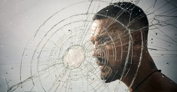 Crack. macho man behind crushed glass. anger. destruction. crush test. theft. emotional discharge. bullet hole in glass. broken glass because of hit. sexy hispanic man broken mirror. crack in glass — Stock Photo, Image