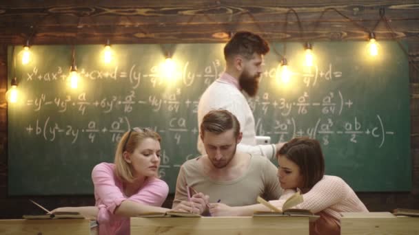 Groupe d'étudiants étudiant ensemble dans une salle de classe, groupe de quatre jeunes étudiants avec enseignant dans la salle de classe de l'école avec ordinateur portable. Éducation, école, collège et université concept . — Video