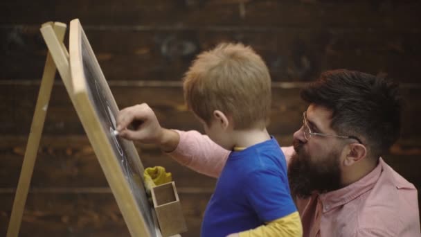 Little Boy rysowanie kredą na tablicy. Edukacja wczesnoszkolna i koncepcja gry. Nauka Chalkboard. Kreatywność i sztuka edukacyjna zabawka. Koncepcja uczenia się. Dzień rodziny, ojciec i syn. — Wideo stockowe