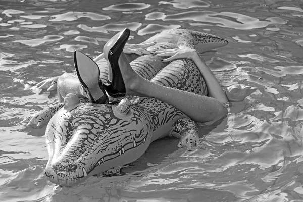 Nő a tenger, a felfújható matrac. krokodil bőr cipő. női lábak matrac medencével tart. A krokodil bőr cipő divat. Lány a nyaralás a krokodil kalandjai. — Stock Fotó