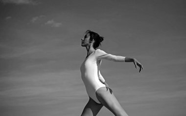 Her harekette güzellik. Dans giyen güzel bir kız. Mavi gökyüzünde dans eden genç balerin. Sevimli bale dansçısı. Klasik bale sanatı pratik. Konser performans dansı. Klasik dans stili