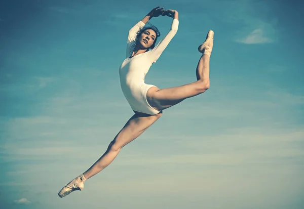 Practicando el arte del ballet clásico. Joven bailarina saltando sobre el cielo azul. Bonita mujer en ropa de baile. Linda bailarina de ballet. Baile de concierto. Estilo de baile clásico. Clase de ballet. Sentirse libre —  Fotos de Stock