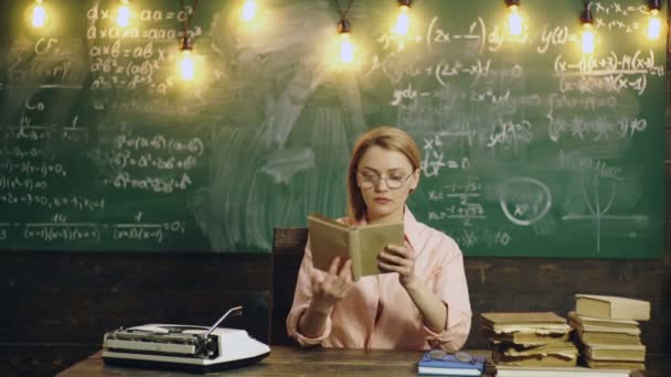 Young female student read book in front of the chalkboard. Portrait of young teacher reading book by blackboard in the classroom. Classmate Educate Friend Knowledge Lesson Concept. Teacher in — 비디오