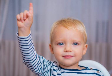 Harika bir fikrim var. Boy sevimli yürümeye başlayan mavi gözleri yukarı işaret parmağını işaret ediyor. Yaratıcı fikir kavramı. Parlak bir çözüm. Sembol fikri. Genç neslin görünümü. Sevimli çocuk fikir ile gelip