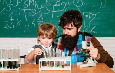 Sınıfta mikroskop kullanan öğretmen ve öğrenci. Wunderkind' e. Bilim ve eğitim kavramı. Evde öğrenmek. Eğitim ve öğretim kavramı. Bilgi günü. Öğretmen