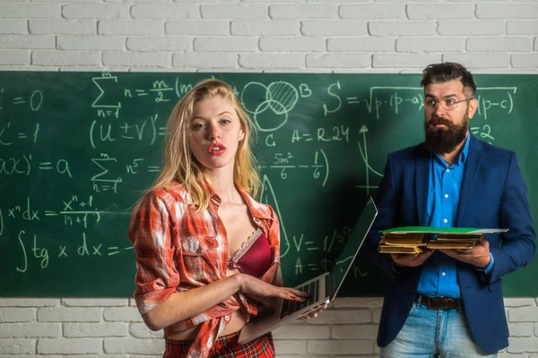 Professor com alunos. Jovem professor atraente apontando para quadro. Estudante sexy apontando para quadro-negro. aluna sexy com belo peito e professora em sala de aula . — Fotografia de Stock