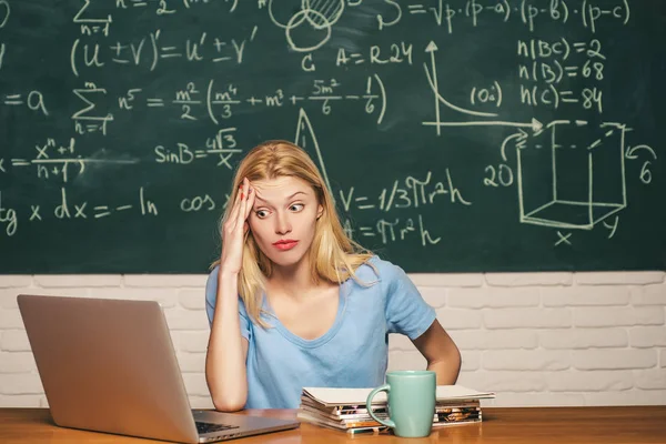 Donna freelance con buon umore utilizzando il computer portatile. Ritratto di studentessa seria e stanca. Avviamento. Dopo il lavoro. Studente stanco che impara a casa . — Foto Stock