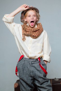 Sürpriz. Eski bavulla seyahat edin. Homelss, ne kadar çok şey var? Kirli suratlı sokak çocuğu. vintage İngilizce tarzı. retro model. Vintage askı. bere eski moda çocuk. retro erkek takım elbiseli genç kız