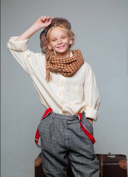 приключение. Девушка-подросток в костюме ретро. Уличный парень с грязным лицом. винтажный английский стиль. Путешествие со старым чемоданом. Хомельс. старомодный ребенок в берете. ретро модель. Винтажная подвеска
