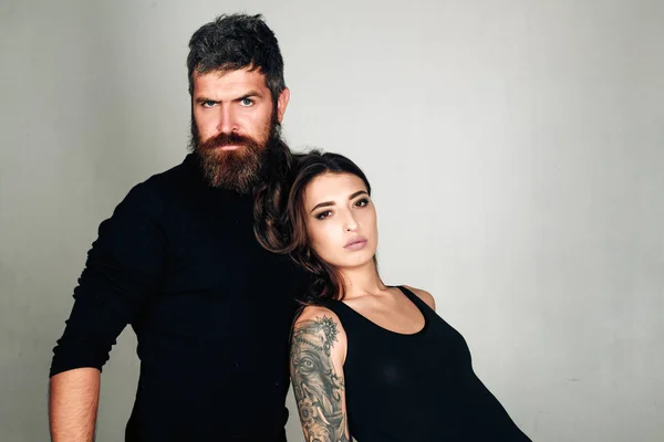 fashion couple. couple in love. brutal bearded man and woman with tattoo. hairdresser and barbershop. tattoo salon. male beard care. hipster man with sexy girl. relationship. serious emotions