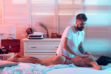 Güzellik salonu ve spa. Sevgililer spa masajı. Memnuniyet ve zevk. Hedonizm ve vücut zevkleri. Şehvetli bir dokunuş. Çift yatakta rahatladı. Erkek ve kız rahatlatıcı şehvetli vücut masajı. Cinsel masaj