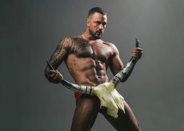 Verlangen is de energie kracht. Sexy Latino man toont zijn seksuele begeerte en aantrekkingskracht. Gespierde Spaanse man met fit lichaam houden schedel en hoorns. Aantrekkelijke kracht en verlangen kracht. Desire concept — Stockfoto