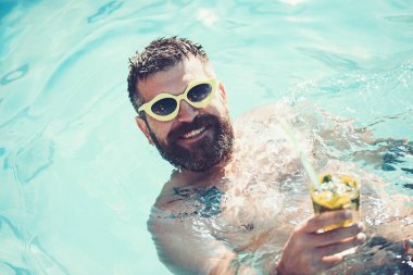 Mojito kokteyl yaz aylarında sakallı adamın elinde. Mojito cam havuz partisinde.