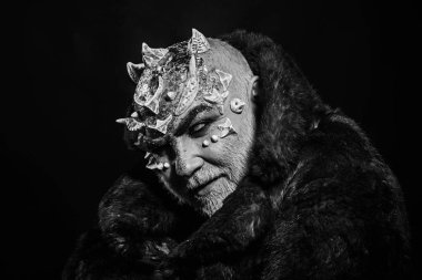 Uzaylı, iblis büyücü makyaj. Korku ve hayal kavramı. Dikenler veya siğiller kürk paltolu adam. Siyah arka plan, kopya alanı cehennemdeki şeytanlar. Beyaz sakallı komuta sizde karanlıkta canavar gibi giyinmiş