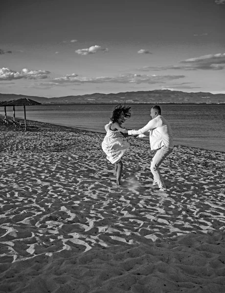 Heureuse famille sur la plage dansant sur le sable . — Photo