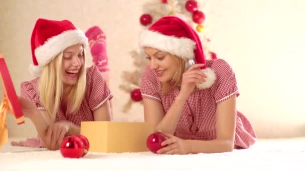 クリスマス気分だ新年の雰囲気を盛り上める2人の幸せな女の子。クリスマスと冬の休日おめでとう。クリスマスツリーの近くで遊ぶ女の子の友人. — ストック動画