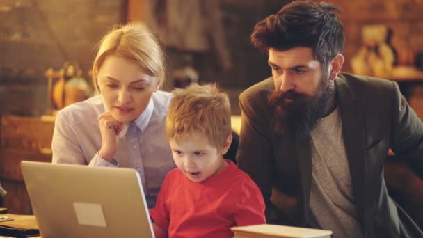 Mutlu bir aile birlikte film izliyor. Birlikte çizgi film izlemek için dizüstü bilgisayar kullanarak anne ve baba arasında dizüstü bilgisayar ile çocuk çocuk. Aile zamanı, mutluluk, hayattan zevk. Aile portresi. — Stok video