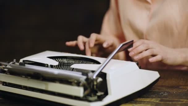 Close up de escritores mãos impressões na máquina de escrever vintage. A escrever na velha máquina de escrever. Mão das mulheres digitando na máquina retro. Os escritores mãos em uma máquina de escrever começam a escrever . — Vídeo de Stock