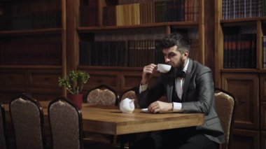 Ev ve lüks konsepti. Sakallı adam evde çay ya da kahve içer. Sakin yüzlü olgun adam ikindi çayı nın tadını çıkarır. Müşteri lüks kafede oturur ve içecekler prim çay. Şık takım elbiseli sakallı adam.