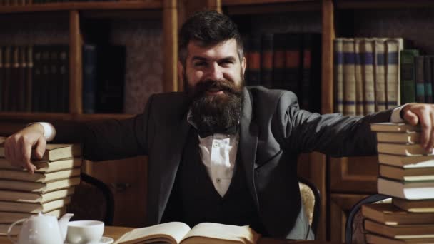 Portrait of funny bearded man with many books in in the library. Nerd funny student preparing for university exams. Funny scene of a very busy lawyer with too many books to read. — Stock Video