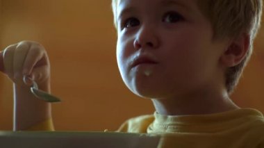 Mutlu erkek bebek kaşık kendini yiyor. Küçük bebek portre yiyerek yakın.
