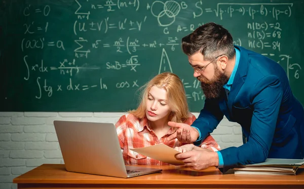 Teacher collaborates with colleagues. Back to school and Education concept. Young teacher near chalkboard in school classroom. Blackboard for copy space text. — Stock Photo, Image