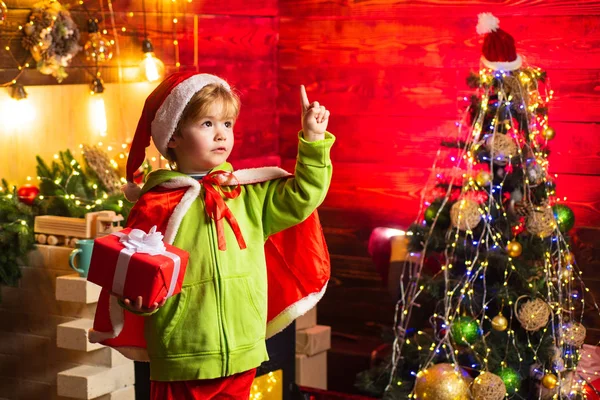 あなたの家族のために最高の願いこのクリスマス。メリークリスマスと幸せな新年。かわいい子供の男の子はクリスマスツリーの近くで遊ぶ。子供は家で冬の休日を楽しむ。喜びと愛に満ちた家 — ストック写真