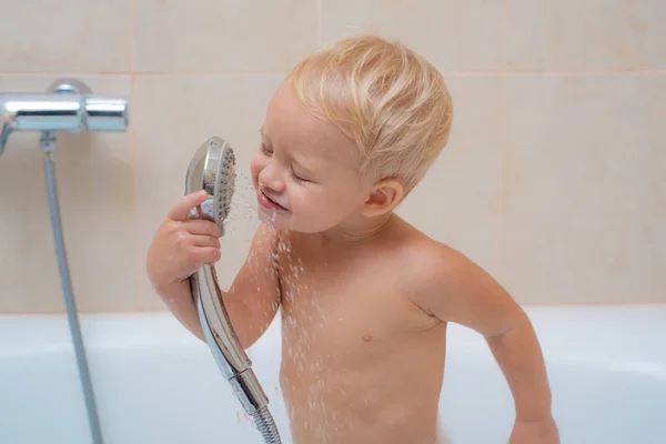 Babafürdő. Játék a kádban. Gyermekmosás és fürdés. Imádnivaló baba szappanos szappanhab a haj vesz fürdő. — Stock Fotó