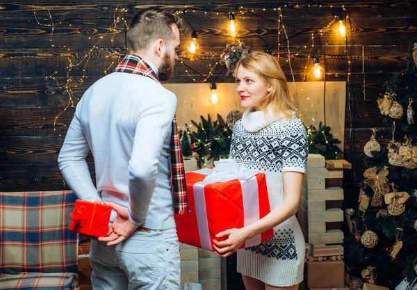 Homme hipster donner un cadeau à fille décorations de Noël fond. Surprise pour ma chérie. Joyeux Noël et bonne année. Cadeaux de Noël. Homme beau avec boîte cadeau surprise pour petite amie — Photo