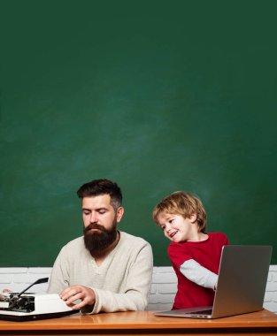 Öğretmen okulda sınıfta ödevlerini çocuklara yardım ediyor. Çocuk öğrenme. Evde. Okuldaki ilk gün. Mutlu bir aile - baba ve oğul birlikte. Genç veya yetişkin.