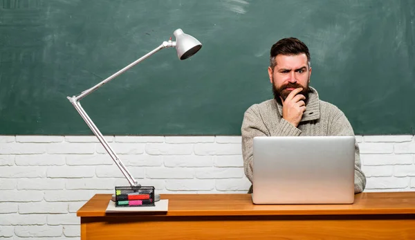 학교 및 교육 개념으로 돌아가기. 테이블에 앉아서 노트북에 쓰는 학생. 학교로 돌아갑니다. 수염이 있는 선생. — 스톡 사진