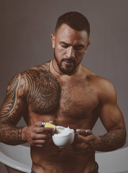 Shaving with a real blade sounds cool. Muscular latino man preparing shaving cream. Handsome hispanic guy holding shaving brush in strong hands. Bearded man going to shaving his facial hair