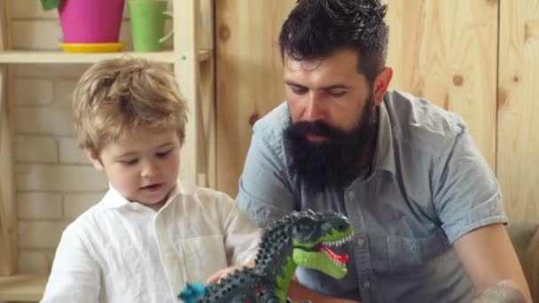 幸せな子供時代。ホーム恐竜公園。息子と父親は、ジュラ紀に再生します。家族の誕生日の贈り物に最適のグッズ恐竜。髭の男は小さなかわいい男の子で再生します。. — ストック動画