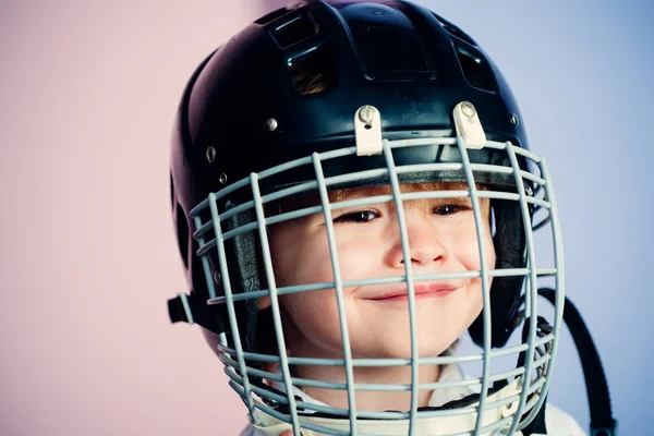 Safety and protection. Protective grid on face. Sport equipment. Hockey or rugby helmet. Sport childhood. Future sport star. Sport upbringing and career. Boy cute child wear hockey helmet close up