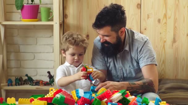 Buen concepto de crianza. Un niño pequeño con papá jugando juntos. Padre e hijo juegan. Feliz ocio familiar. Hijo del amor. Desarrollo infantil. Edificio con constructor de color. Buena crianza . — Vídeos de Stock